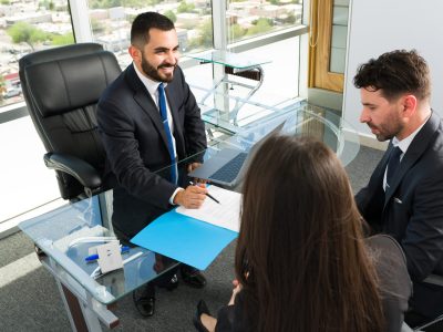 Giving good legal information. Company executives having a meeting with a sales representative and about to sign a new business deal at a modern office